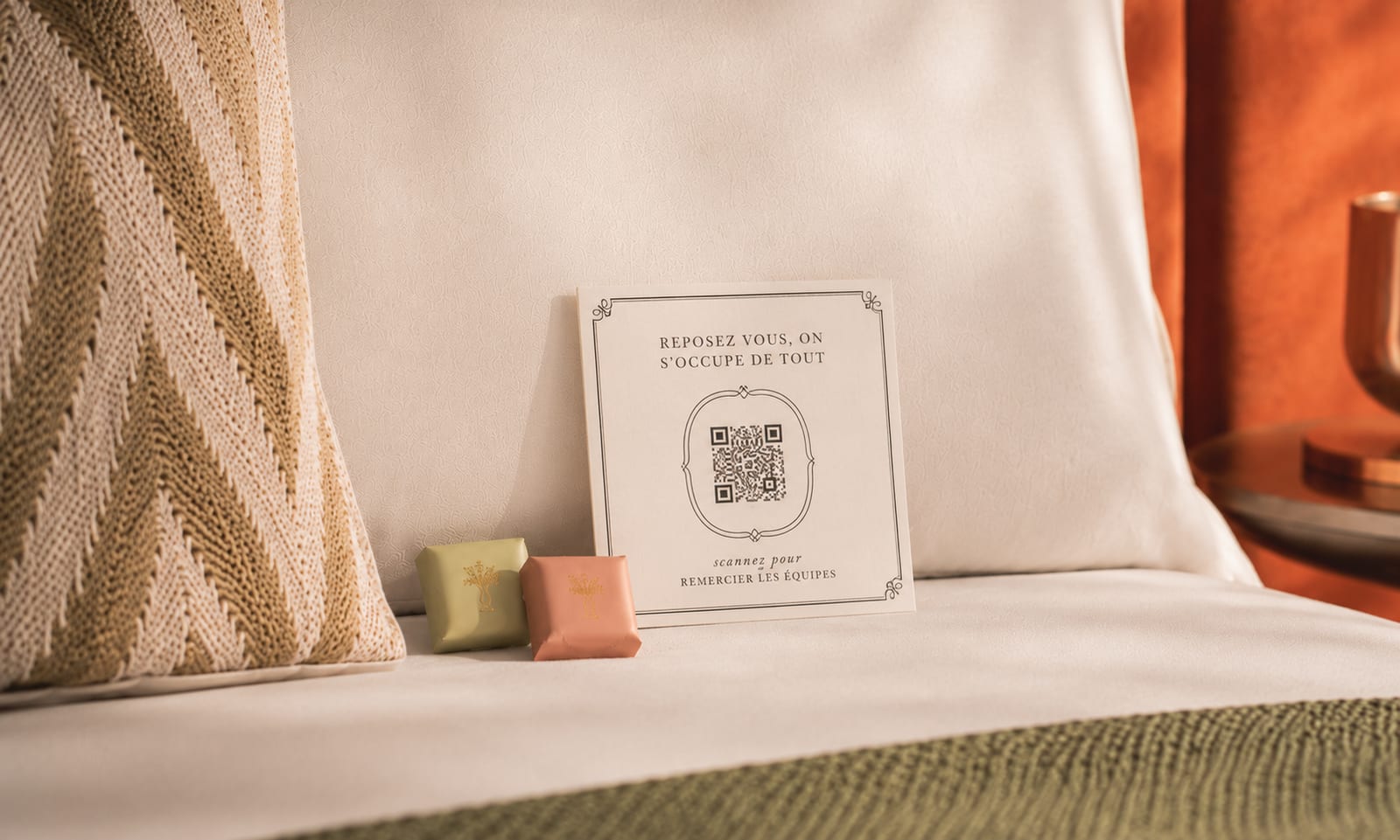 Carte QR CaptainTips posée sur un lit d’hôtel